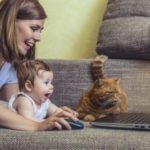 Frau mit Kind und Katze am Laptop